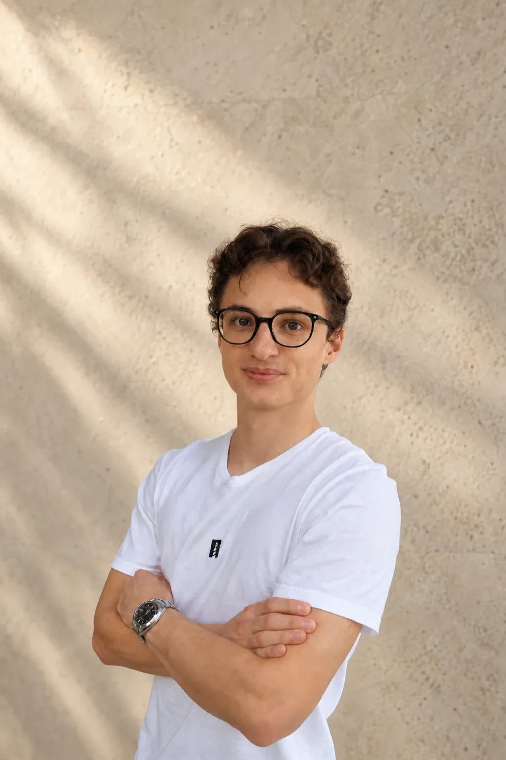 Gabriel Battlogg wearing a white North T-shirt against a warm stone wall